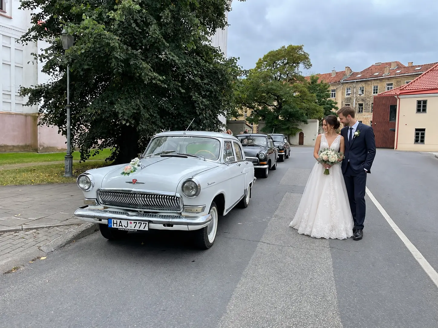 Balta „Volga“ su jaunavedžiais ir automobilių kolona