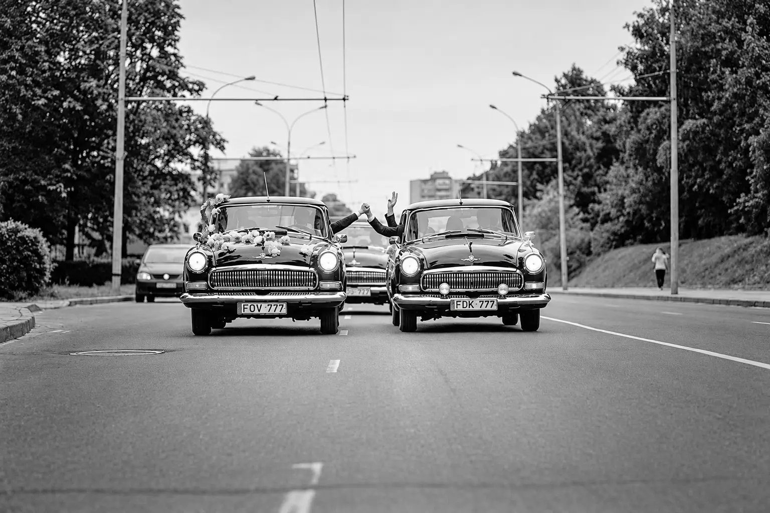 Trys retro automobiliai „Volga“ važiuoja miesto gatve